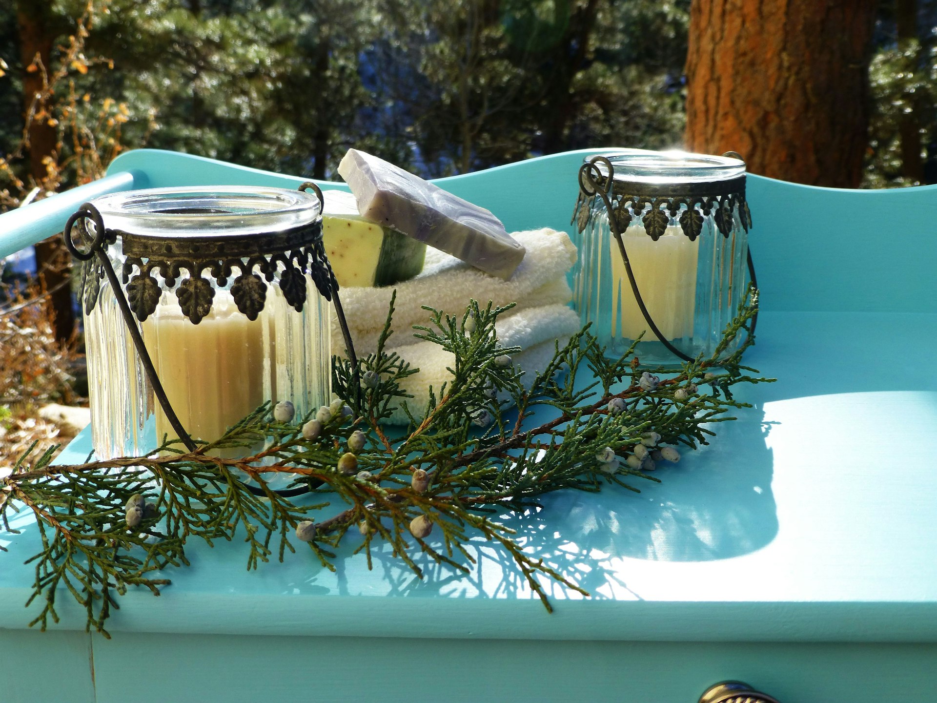 Two candles and towels on a blue table.
